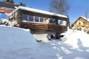 a house in the snow with a pile of snow at Ferienhaus Oberwiesenthal in Kurort Oberwiesenthal