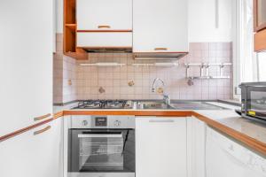 a kitchen with white cabinets and a sink at Casa da Suite Cavour in Corsico
