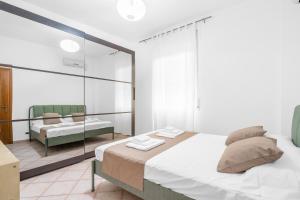 a white bedroom with a bed and a mirror at Casa da Suite Cavour in Corsico