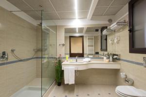 La salle de bains est pourvue d'un lavabo, d'une douche et de toilettes. dans l'établissement As Hotel Cambiago, à Cambiago