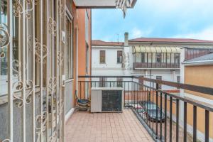 einen Balkon mit einem Tor und Blick auf einige Gebäude in der Unterkunft Casa da Suite Cavour in Corsico