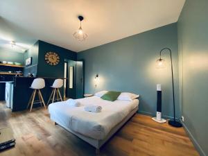 a bedroom with a large bed with blue walls at Casa Balzac - Studio in Angers