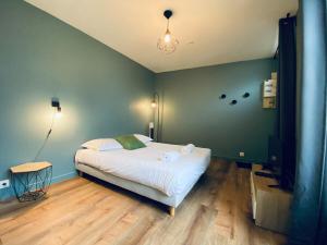 a bedroom with a white bed and a green wall at Casa Balzac - Studio in Angers