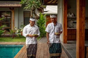 deux hommes se tiennent à côté d'une piscine dans l'établissement Villa Zarrin Seminyak Bali Luxury 3 bedroom villa, à Seminyak 21 autres photos