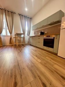 a kitchen with wooden flooring and a kitchen with a stove at Sublime T3 centre Ajaccio, équipé et climatisé in Ajaccio