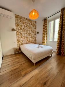 a bedroom with a bed and a lamp and wooden floors at Sublime T3 centre Ajaccio, équipé et climatisé in Ajaccio +13 photos