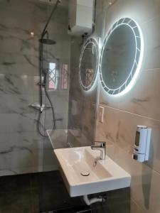 JLK Guest House & Events Centre في Koforidua: حمام مع حوض أبيض ومرآة