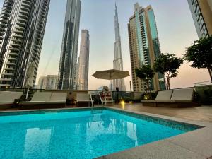 a swimming pool in the middle of a city with tall buildings at Fabulous 2BR l High Floor l by Burj Khalifa & Dubai Mall I Pool I Gym in Dubai