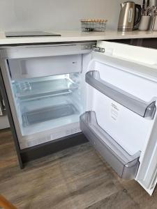 an empty refrigerator with its door open in a kitchen at Boutique Annexe Close To Central Norwich & Airport in Norwich