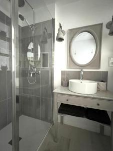 y baño con lavabo y ducha con espejo. en La Maison de Manou, en La Noë-Poulain