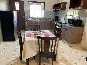 una cucina con tavolo, sedie e frigorifero di Casa acogedora en Alto Boquete, Las Trancas 2 a Boquete