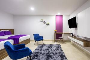 - une chambre avec un lit, deux chaises et une télévision dans l'établissement WinDay Hotel Express, à Veracruz