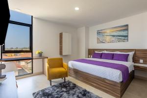 um quarto com uma cama grande e uma cadeira amarela em WinDay Hotel Express em Veracruz