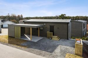 a small house with a roof on a lot at Modern house near the ocean in Sandefjord