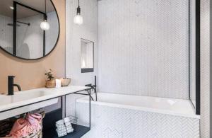 a bathroom with a tub and a sink and a mirror at Modern house near the ocean in Sandefjord
