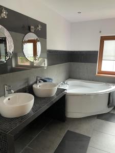 Dom wakacyjny przy szlakach turystycznych في Jastrowie: حمام مع مغسلتين وحوض استحمام