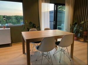 mesa de comedor con 4 sillas y ventana grande en Modern house near the ocean, en Sandefjord