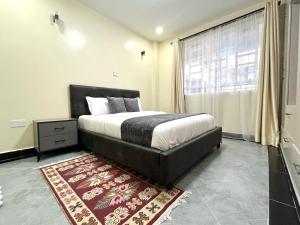 a bedroom with a large bed and a rug at Naka Executive Suites With Balcony, Amazing Lake Nakuru View, GYM in Nakuru
