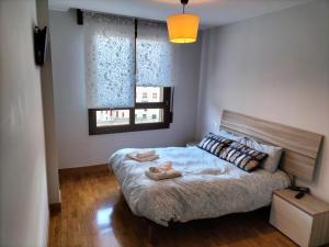 a bedroom with a bed with two towels on it at ALTUNAHOME in Mutriku