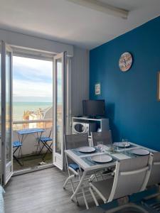 una sala da pranzo con tavolo e sedie e un balcone di AL 31 - La marée Ault a Ault