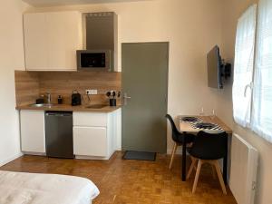 a small kitchen with a desk and a table with a chair at Studio & Coworking Thème Factory A in Morsang-sur-Orge