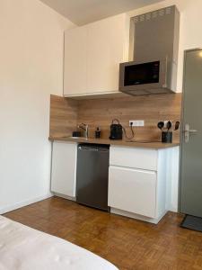 a kitchen with white cabinets and a black dishwasher at Studio & Coworking Thème Factory A in Morsang-sur-Orge +2 photos