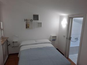 Habitación blanca con cama y ducha en Casa di Via Nuova, en Spoleto