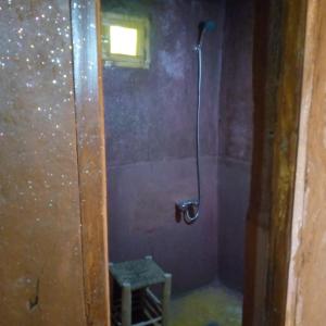 a bathroom with a shower with a stool in it at Camp Mbark authentic in Mhamid