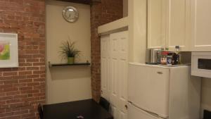 eine Küche mit einem Kühlschrank und einer Uhr an der Wand in der Unterkunft Nest Family Aparthotel - No Window in New York