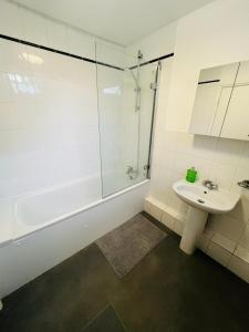 a white bathroom with a sink and a shower at Stay and Explore Easy Central London Access via Jubilee Line in London