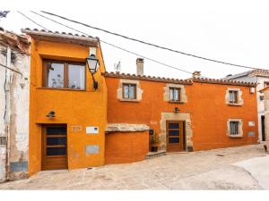 een oranje gebouw met twee deuren in een straat bij Cal Ton in San Quírico Safaja