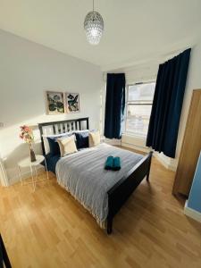 a bedroom with a large bed with blue pillows at Stay and Explore Easy Central London Access via Jubilee Line in London