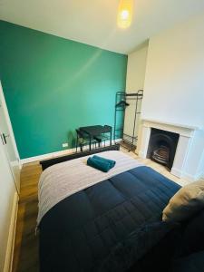 a bedroom with a bed and a green wall at Stay and Explore Easy Central London Access via Jubilee Line in London