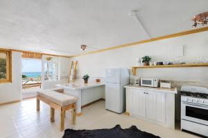 uma cozinha com um frigorífico branco e uma mesa em Surfers Bay Resort em Christ Church