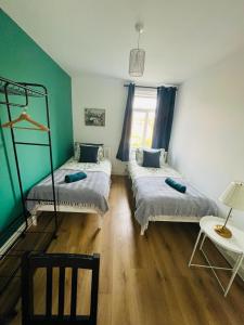 a room with two beds and a table and a window at Stay and Explore Easy Central London Access via Jubilee Line in London