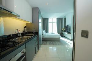 a kitchen with a sink and a room with a bed at Prive -Luxury studio in Dubai