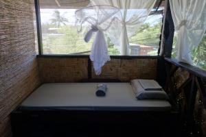 a small bed in a room with a window at Mi Casa Suites Siargao in General Luna