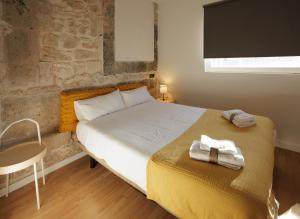 a bedroom with a bed with towels on it at Villanubla Apartaments in Villanubla
