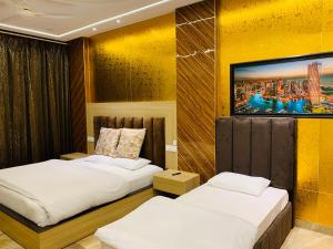 two beds in a room with yellow walls at HolidayVilla-A Residential Boutique Hotel-Newly Renovated in Amritsar