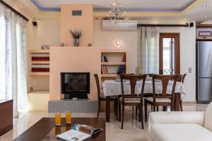 a living room with a dining table and a fireplace at Gavriella House in Mélanes