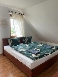 Dom wakacyjny przy szlakach turystycznych في Jastrowie: سرير مع لحاف أخضر في غرفة النوم