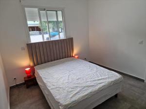 1 dormitorio con 1 cama con 2 lámparas en Au Petit Paradis, en Saint-François