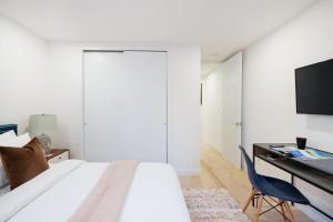 Dormitorio con cama, escritorio y TV en 75-3B 3BR Luxury duplex BRAND NEW &D Elevator, en Nueva York