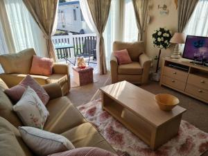 uma sala de estar com um sofá e uma mesa de centro em Sea Shore Chalet - Rockley Park em Lytchett Minster