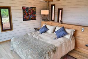 a bedroom with a bed in a room with wooden walls at Casa en Lago Vichuquén, sector la queseria. in Llico