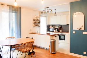 een keuken met een tafel en stoelen en een tafel en een aanrecht bij Family cocoon with balcony in Pantin