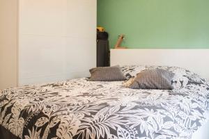 een slaapkamer met een bed met een zwart-wit dekbed bij Family cocoon with balcony in Pantin