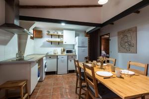 cocina y comedor con mesa de madera y sillas en Apartamentos Econatur en Rubiales