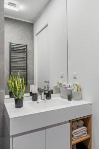ブカレストにあるONE Verdi Luxury Apartmentsのバスルーム(白いシンク、植物付) +128枚の写真
