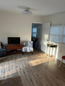 a living room with a tv and a couch and a table at Nature Coast Inn & Cottages in Inglis